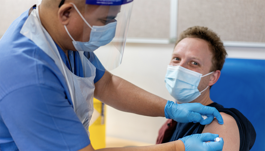 A member of staff receives the COVID-19 vaccine