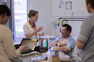 Alison Pottle talking to a patient on a ward round