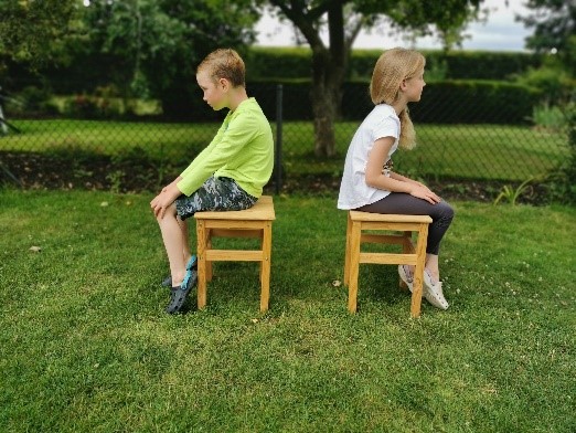 Two children sitting slouched on chairs, demonstrating bad posture